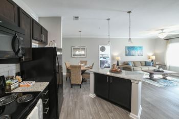 An open kitchen and living room with a couch and a table